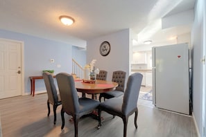 A dining room with a round table, six chairs, a clock, and a refrigerator in the background. - 2 Mi to Campus! Convenient Townhome in Normal (Normal)