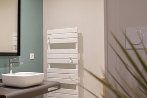 A bathroom with a white sink, a mirror, and a towel rack. - Joli studio spacieux en hypercentre (La Rochelle)