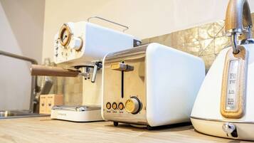 Une cuisine équipée d’une machine à café, d’un grille-pain et d’un appareil à pain, le tout posé sur le plan de travail.