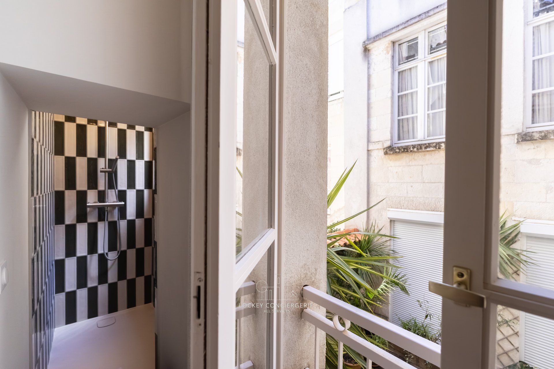 Une salle de bain avec un mur recouvert de carreaux à motifs et une douche.