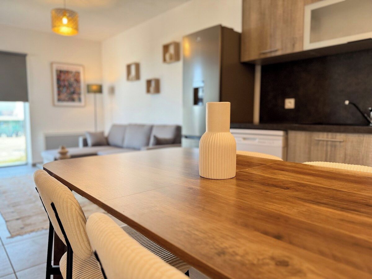 Une cuisine moderne avec un plan de travail en bois et un vase blanc.