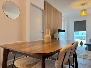 Et moderne spiseområde med et træbord og polstrede stole.