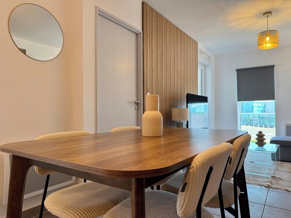 Un espace repas moderne avec une table en bois et des chaises rembourrées.