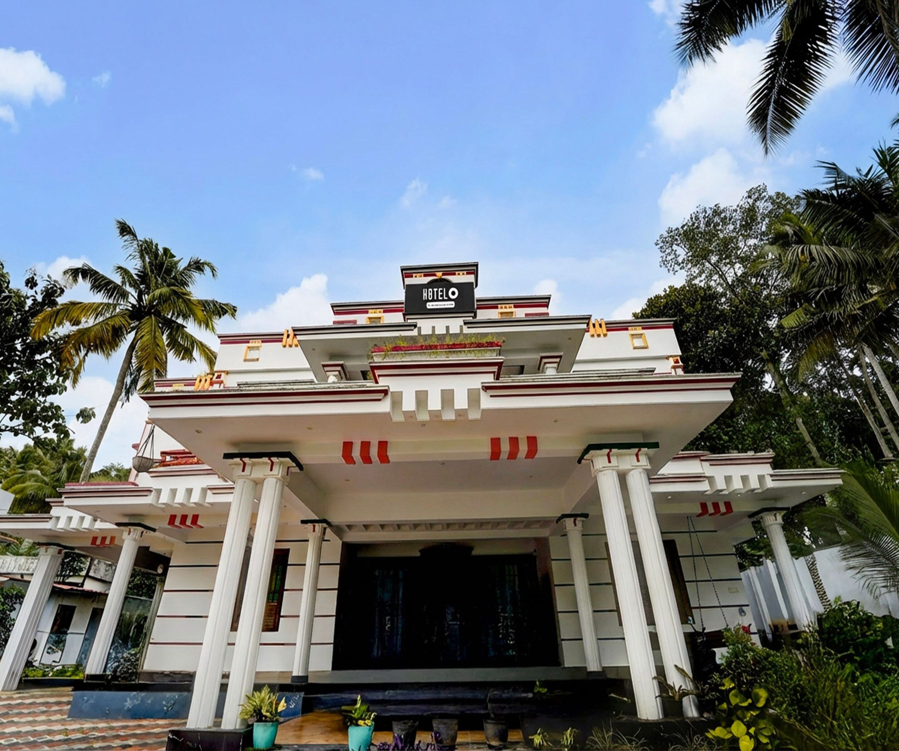 A hotel with a prominent entrance, a signboard, and a symmetrical facade with columns.
