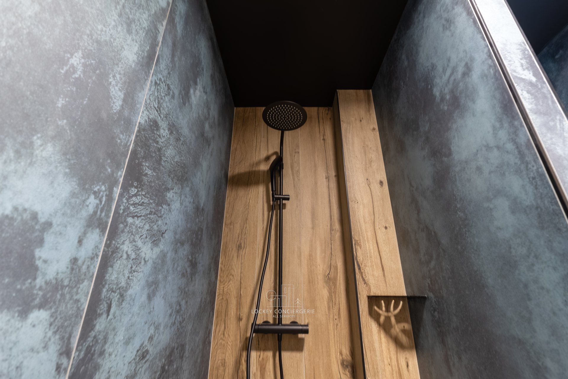 Ducha con panel de madera y cabezal negro.
