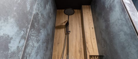 Ducha con panel de madera y cabezal negro.