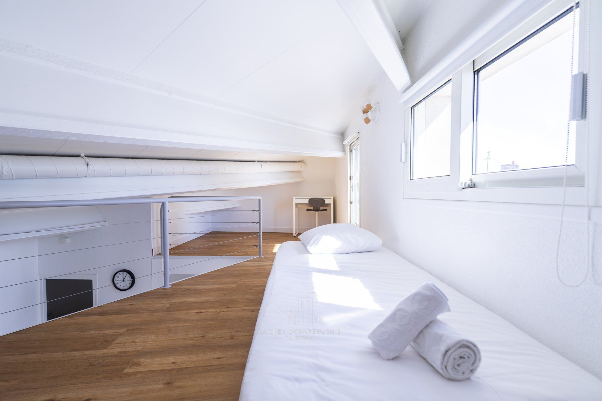 Una camera d'albergo dallo stile minimalista con un letto a castello, una scrivania e una finestra.