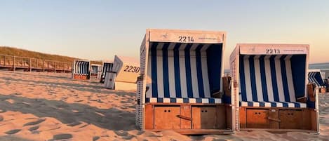 Beachside beach chairs with numbers 2214 and 2213, arranged on a sandy beach.