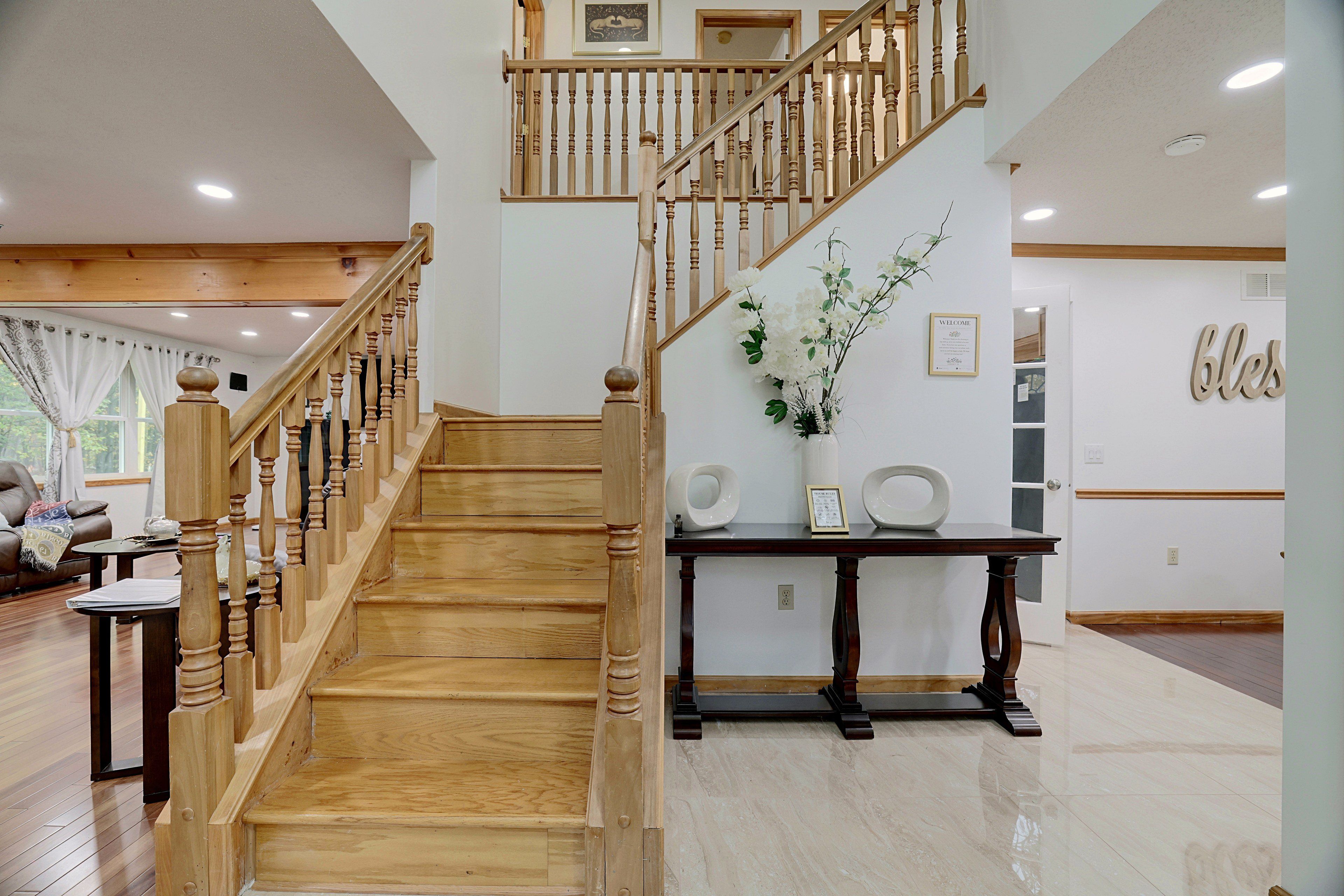 Un escalier en bois avec une rampe, menant à l’étage supérieur.