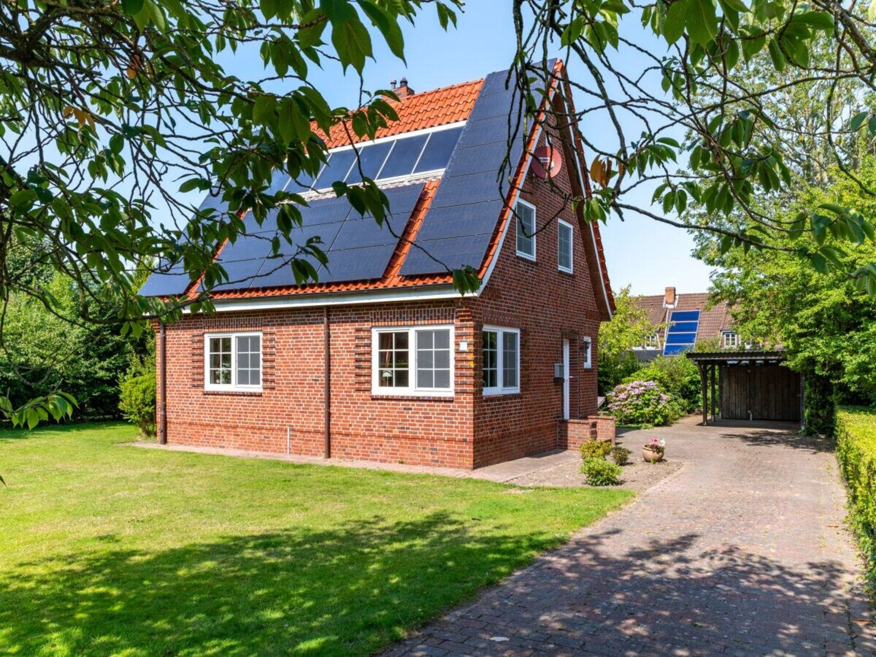 A two-story house with a sloped roof, solar panels, and a brick exterior.