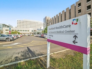 Señal para Hartford HealthCare St. Vincent's Medical Center con flechas direccionales hacia el estacionamiento.