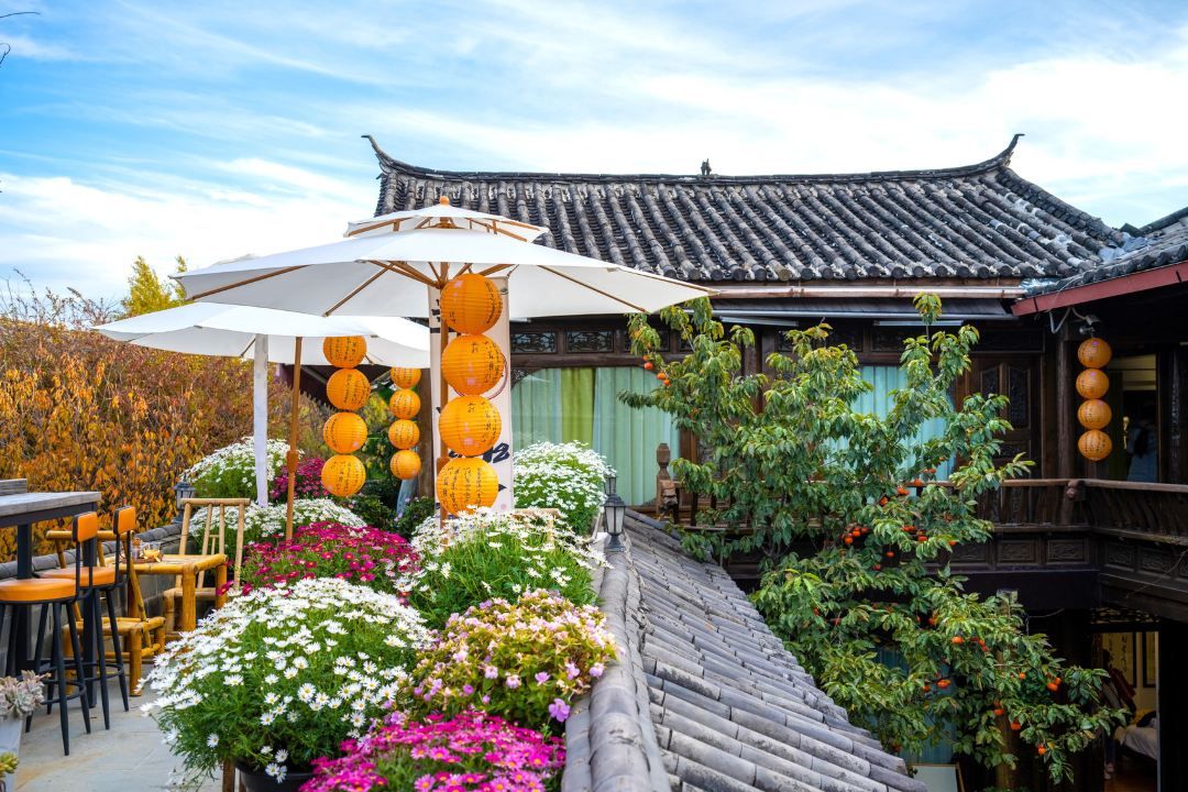 A traditional Japanese-style building with a tiled roof, surrounded by a garden with various plants and flowers.