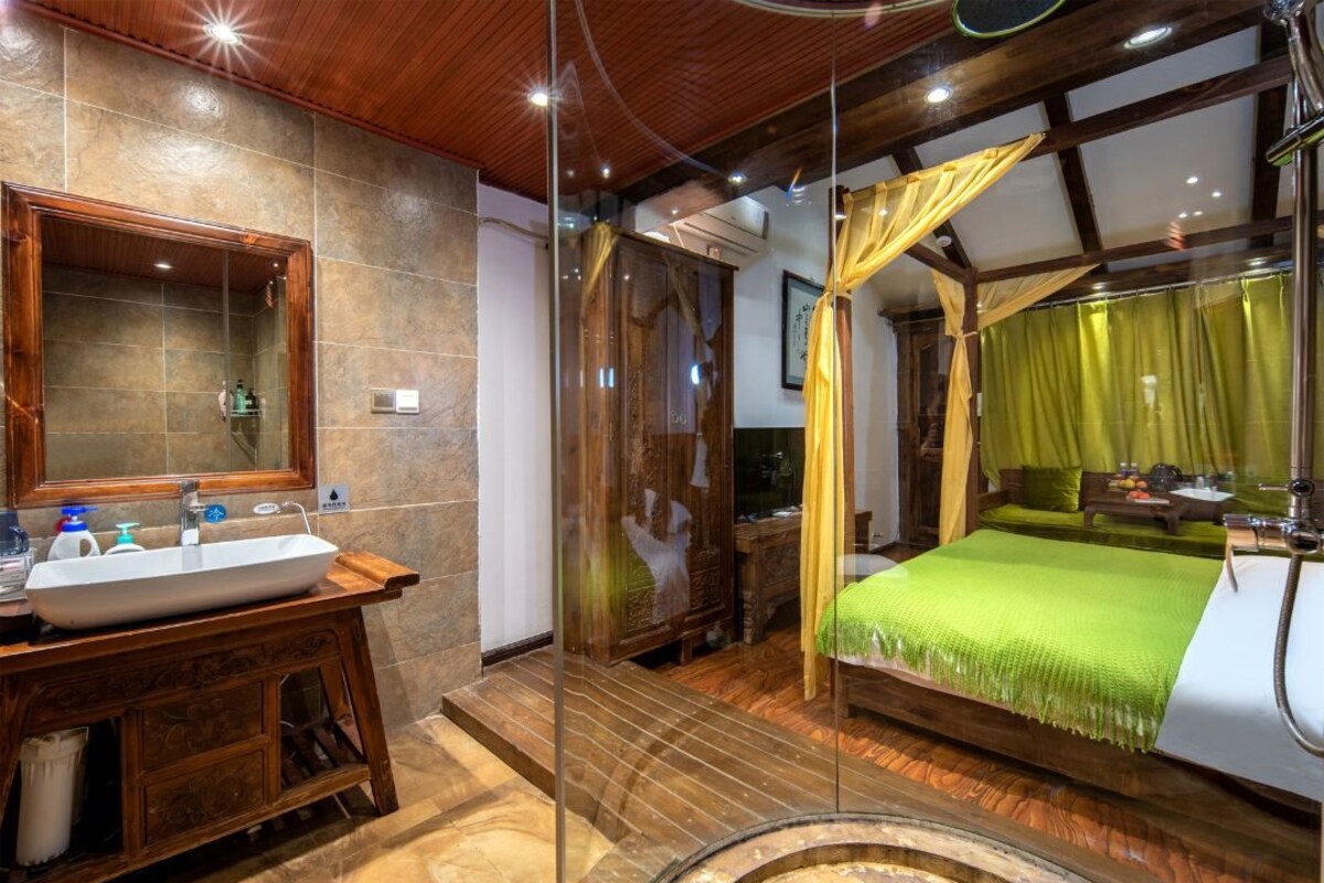 A bathroom with a wooden vanity, a large mirror, and a glass shower enclosure.