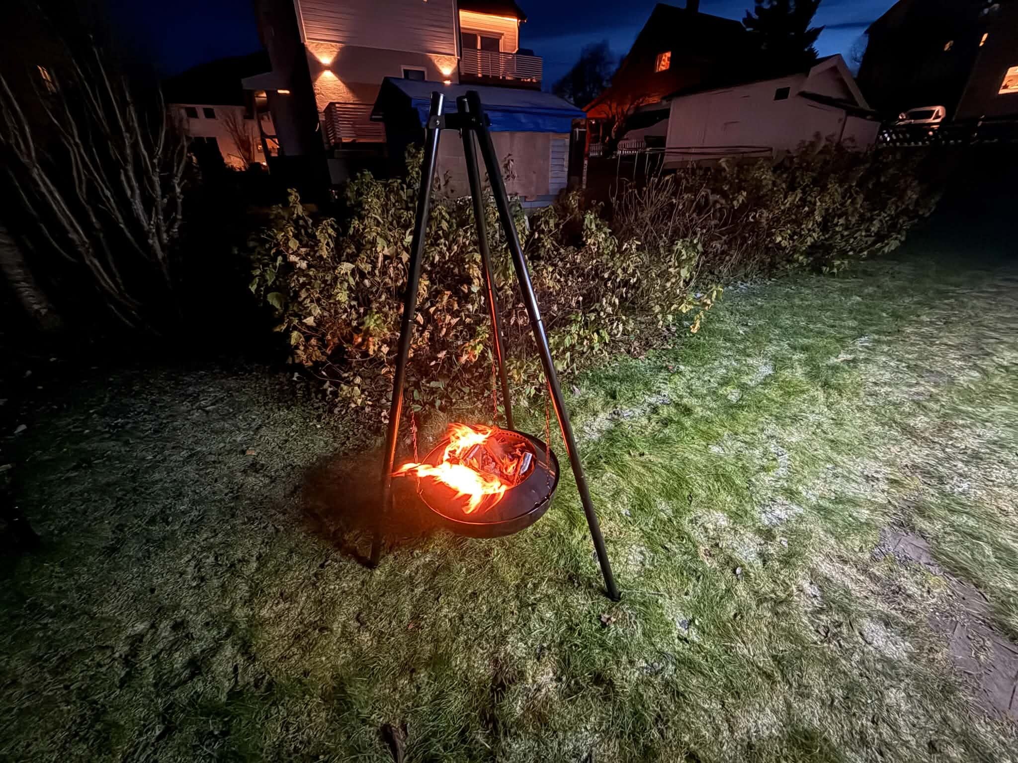 A fire pit in a grassy outdoor area at night.