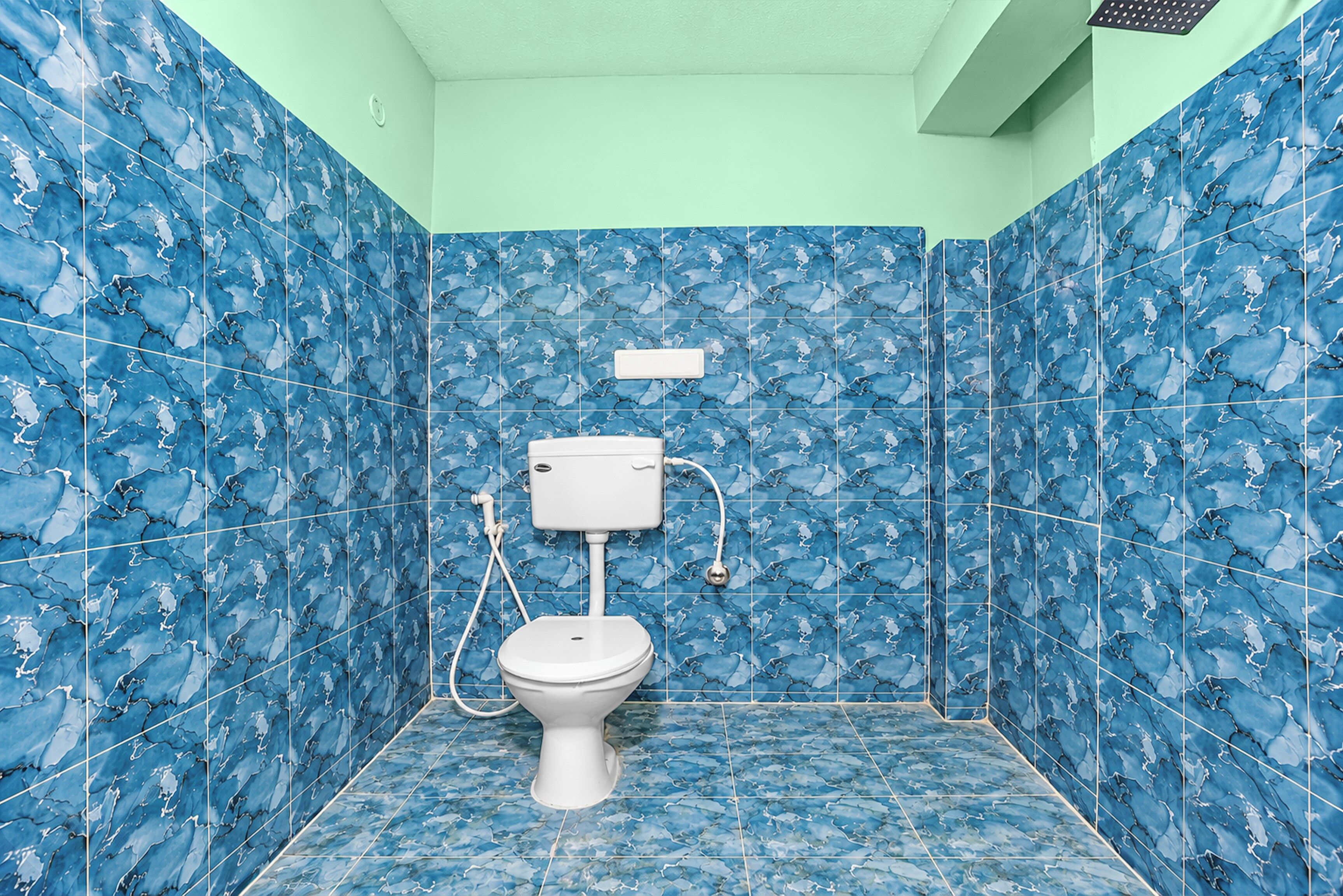Un baño con inodoro, lavamanos blanco y zona de ducha.