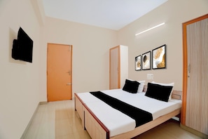 Une chambre à coucher avec un lit, une armoire, une porte et trois tableaux encadrés accrochés au mur.