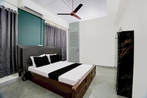 Un dormitorio con cama, cortinas, ventilador de techo y armario.