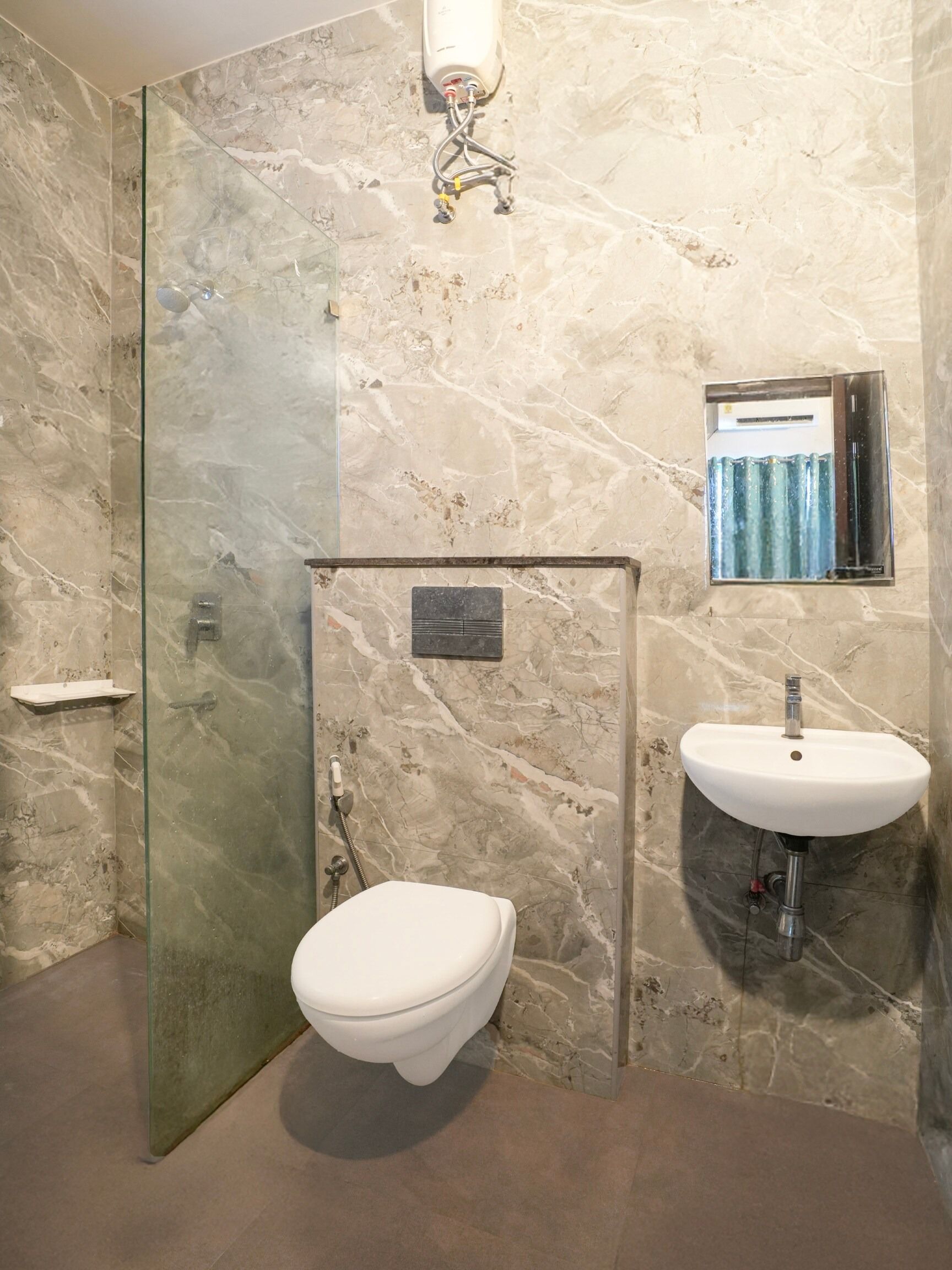 Un baño con ducha envuelta en vidrio, un inodoro blanco y un lavabo con espejo.