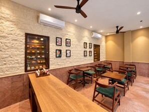 Un restaurant avec un mur en briques, des tables et des chaises en bois.