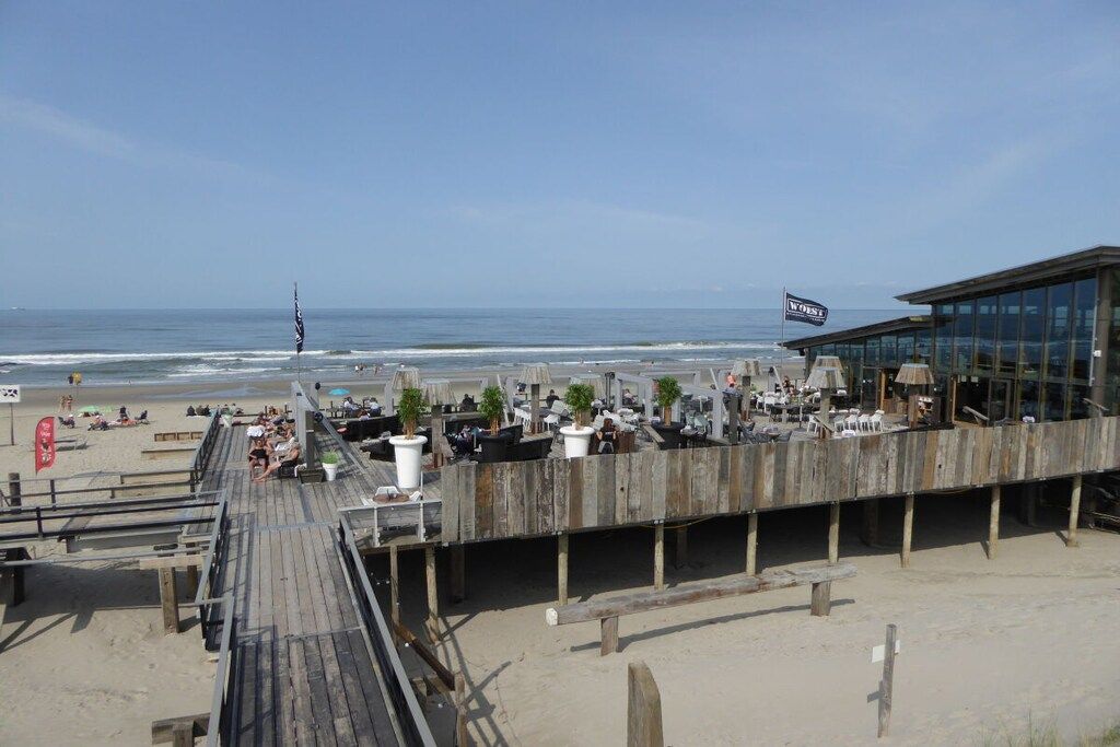 En restaurant ved stranden med udendørs siddepladser med udsigt over havet.