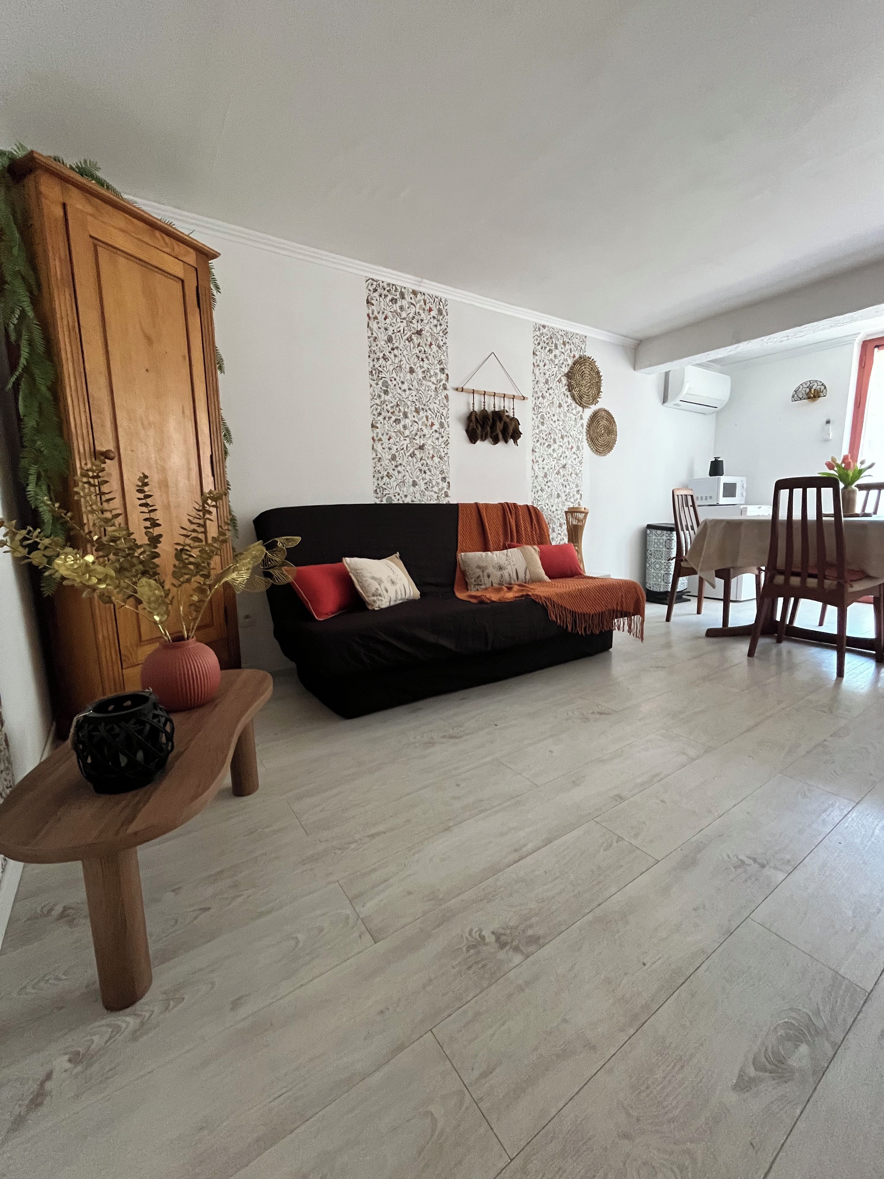 A living room with a black sofa, wooden table, and decorative wall panels.