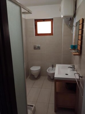 Ein kleines Badezimmer mit Toilette, Bidet und Waschbecken.