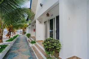 A pathway leading to a building with a number '05' sign, surrounded by palm trees and plants. - Blue Roof Beach Bungalow (Matemwe Zanzibar north coast)