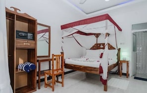 A bedroom with a canopy bed, a wooden wardrobe, a chair, and a bedside table. - Blue Roof Beach Bungalow (Matemwe Zanzibar north coast)
