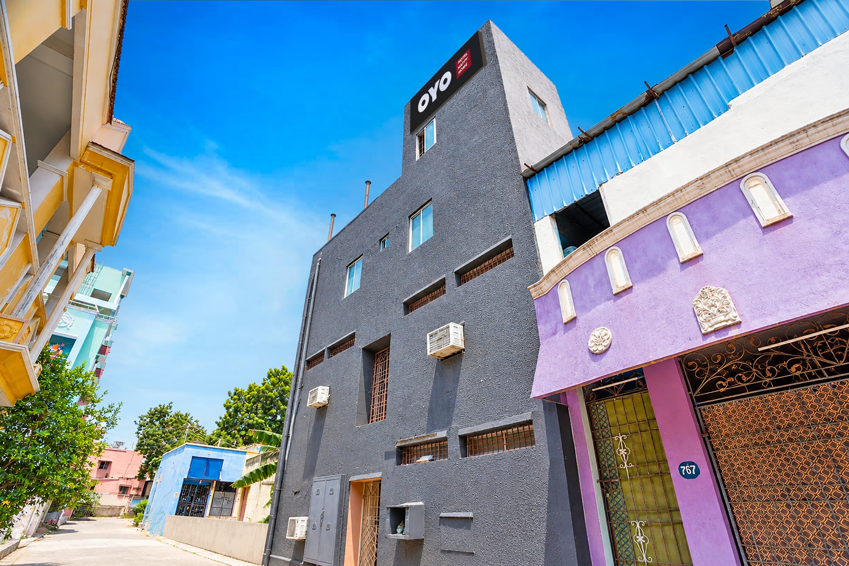 Un immeuble à plusieurs étages sur lequel on peut lire l’inscription : « Hôtel Happy Home ».