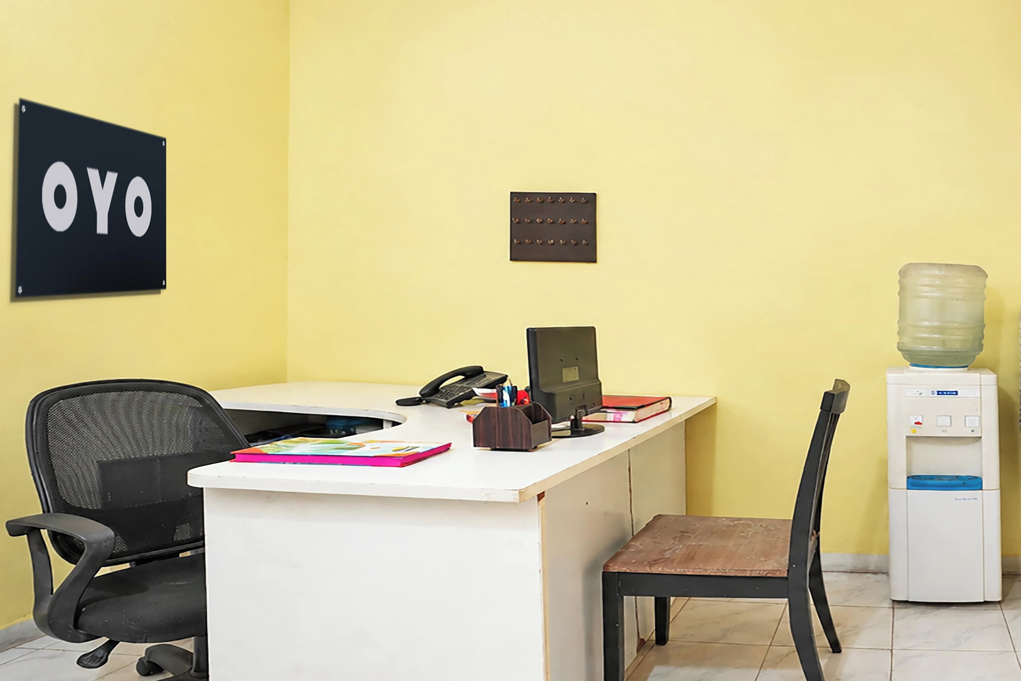 Un bureau équipé d’un bureau, d’une chaise, d’un ordinateur, d’un téléphone et d’un distributeur d’eau.