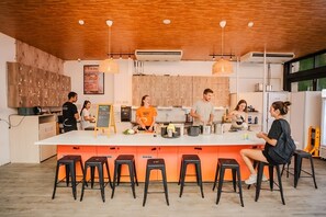 Cozinha moderna com armários de madeira, uma ilha central com bancos e iluminação pendente.