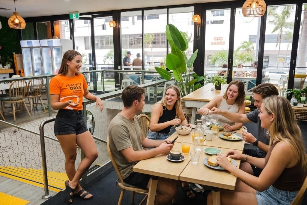 A group of people dining at a restaurant with a view of the street outside.