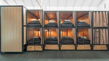 A bunk bed room with a skylight, wooden cabinets, and a ladder.