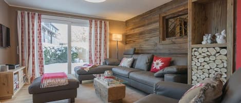 A modern living room with a sofa set, a coffee table, and a television.