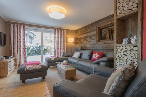 A modern living room with a sofa set, a coffee table, and a television.
