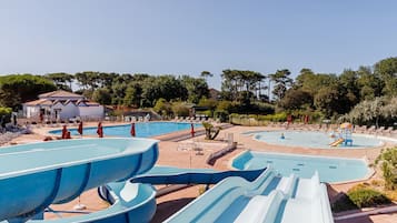 Un parc aquatique doté de nombreux toboggans et de plusieurs piscines, entouré d’arbres et de bâtiments.