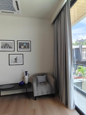 A modern living room with a grey sofa, a small table with a blue vase, and three framed pictures on the wall. - Villa Rangi at Aileen by Tropicloook (Choeng Thale)