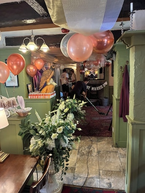Ein Raum mit einer Rezeption, einer großen Blumenkomposition und Luftballons.