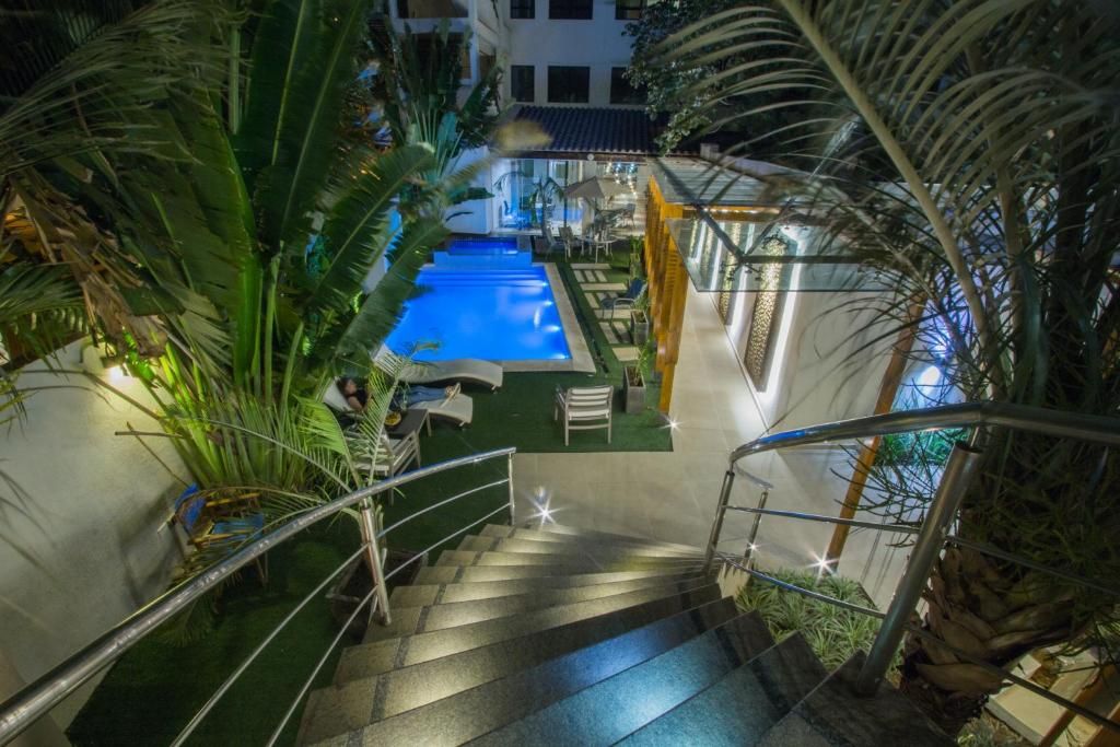 A pool area with a staircase leading to a covered seating area.