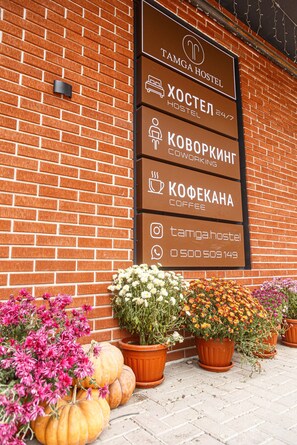 A hostel sign with amenities including a hostel, coworking space, and coffee. - Tamga Hostel Bishkek (Bishkek)