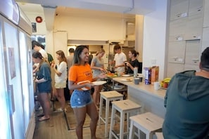 Een moderne keuken met een eethoek, een koelkast en een aanrecht met etenswaren.