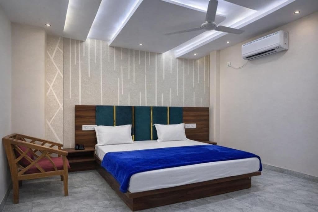 Un dormitorio moderno con cama, mesita de noche, una silla y un equipo de aire acondicionado.