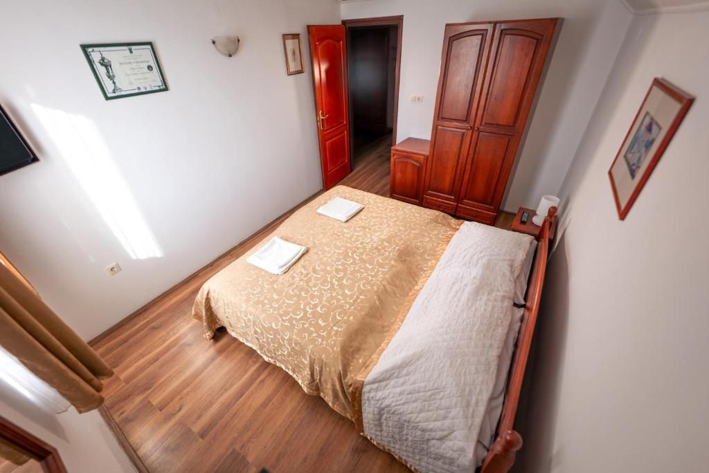 Un dormitorio con cama, armario de madera y puerta que da a otra habitación.
