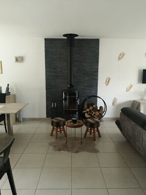 A living room with a fireplace, a sofa, a dining table, and a coffee table. - New Listing (Leigné-sur-Usseau)