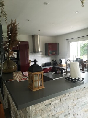 A modern kitchen with a stone backsplash, a built-in oven, and a window providing natural light. - New Listing (Leigné-sur-Usseau)