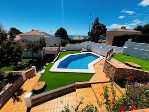 A swimming pool surrounded by a patio area with a view of the sea. - New Listing (Alcocéber)