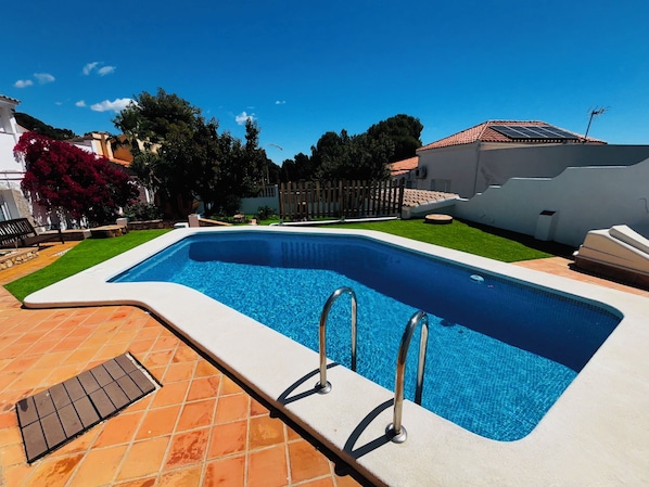 A rectangular swimming pool with a white edge and a tiled deck area. - New Listing (Alcocéber)