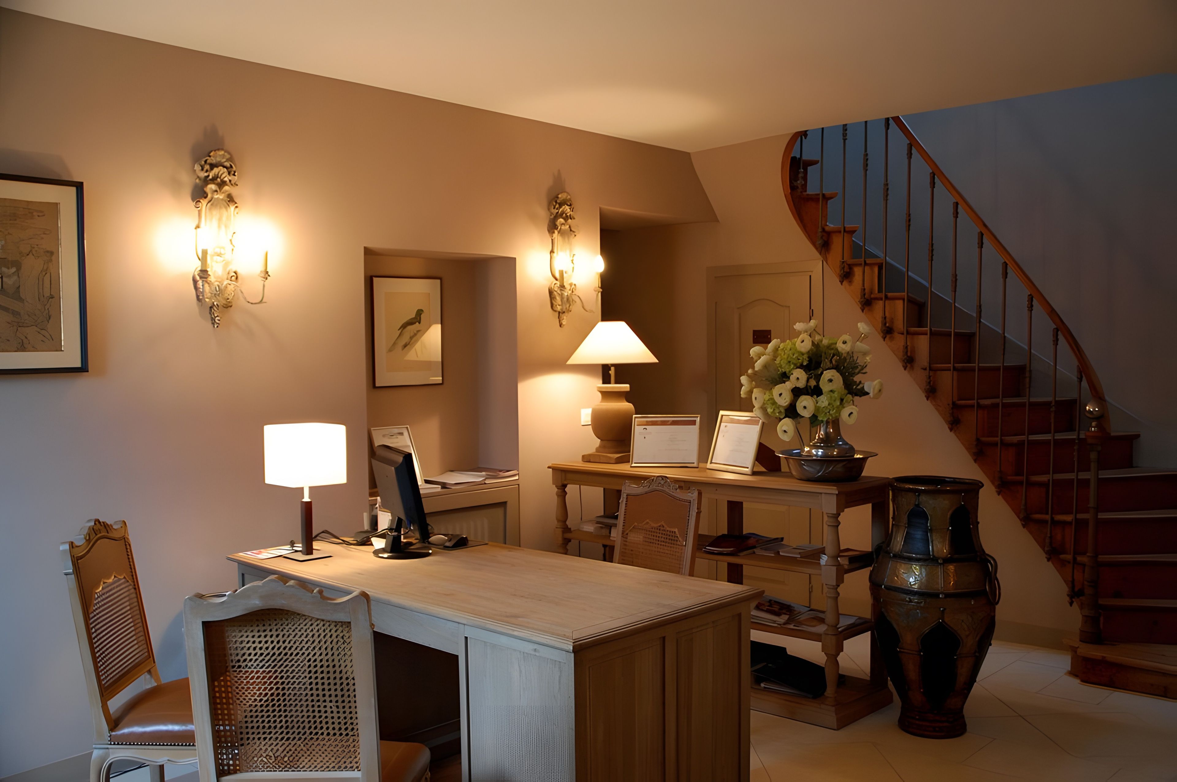 A well-lit room with a desk, chair, and a staircase.