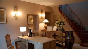A well-lit room with a desk, chair, and a staircase.