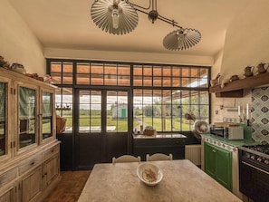 A kitchen with a large window, a dining table, and a stove. - Casal del Falco - Surrounded by Nature (Tarquinia)